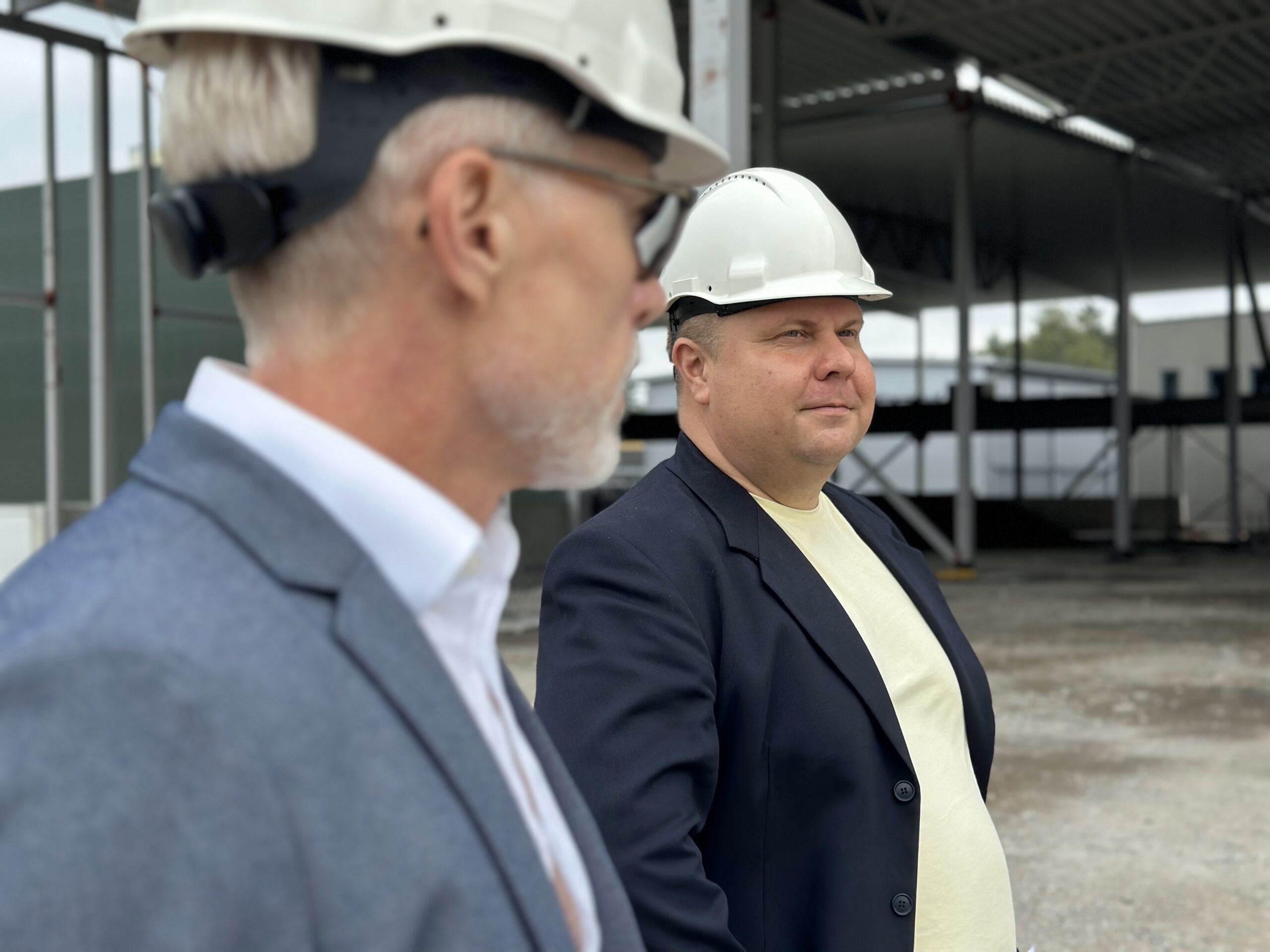 Two men talking by a construction site